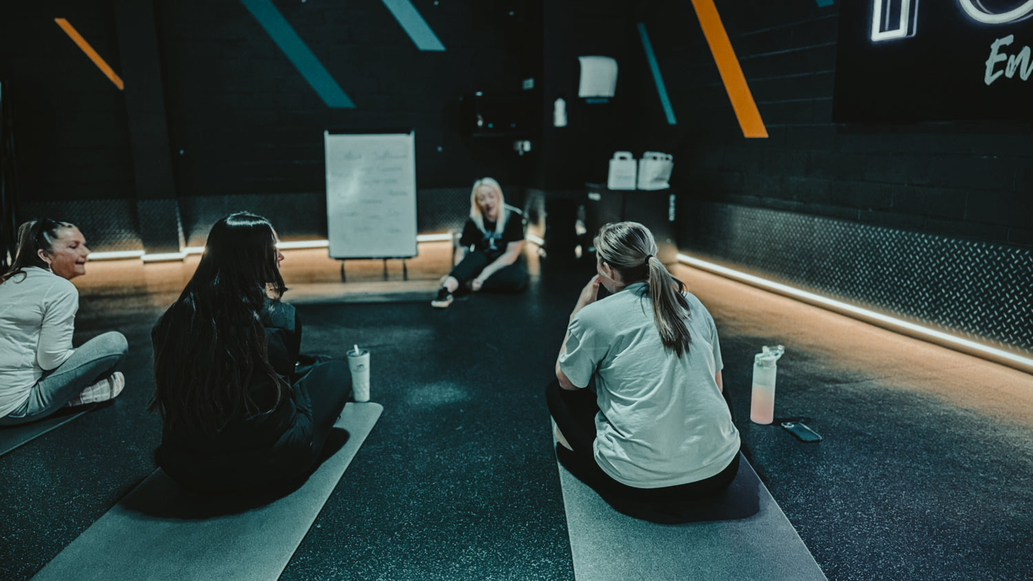 a personal trainer offering advice to a client during a group coaching session