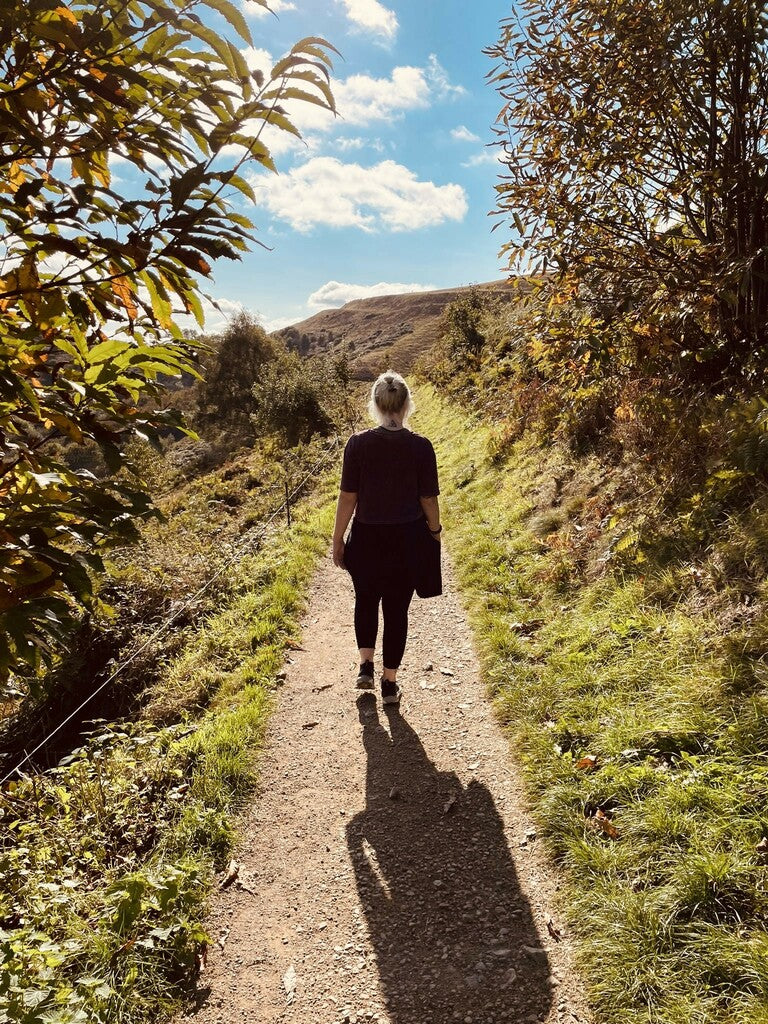 steph from misfit trains hiking up a path